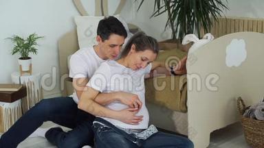 年轻男子抚摸怀孕妻子的腹部